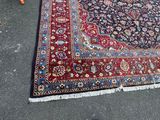 a rug on the ground with a chair and a table in the background