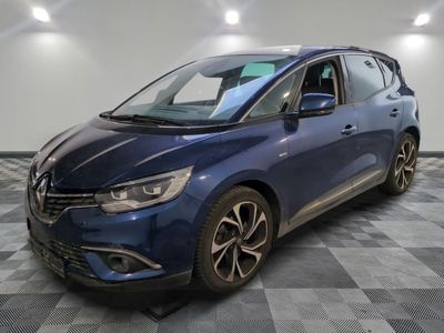 une voiture bleue garée dans un garage au sol en damier