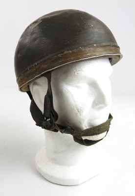 un vieux casque posé sur la tête d'un mannequin, sur une surface blanche