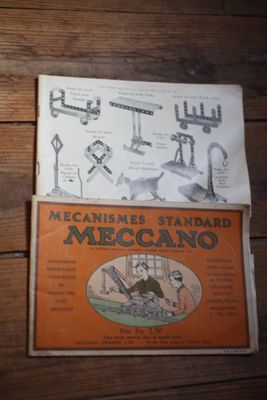 deux livres posés sur une table en bois sur laquelle est dessiné un engin