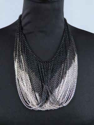une femme portant un haut noir et un collier à chaîne argentée
