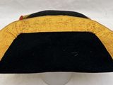 a black and gold hat on a white pedestal
