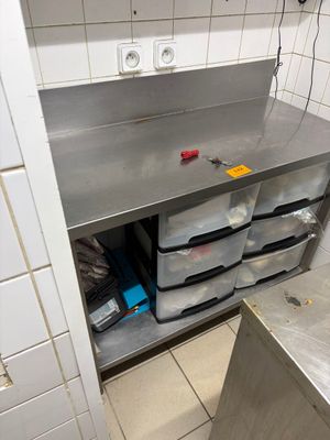 a stainless steel counter with plastic bins on it