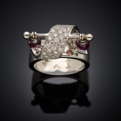 an image of a diamond and ruby ring on a black surface