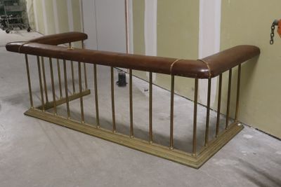 a wooden bench with a brown leather seat in a room