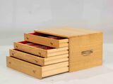 a small wooden box with three drawers on it