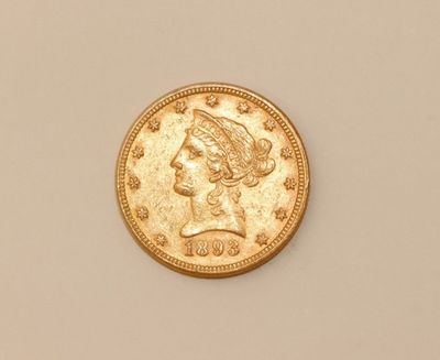 a close up of a gold coin on a white surface