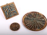 trois pièces de métal et de bois sont posées sur une surface blanche