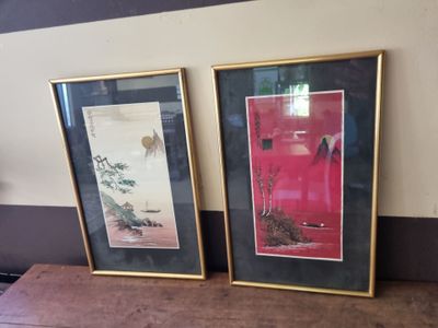 two framed pictures on the wall of a room