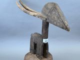 une image représentant une sculpture d'un oiseau coiffé d'un chapeau