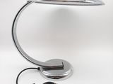 une lampe de bureau argentée surmontée d'une lumière bleue