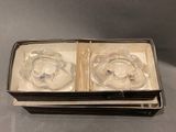 two glass ashtrays in a box on a table