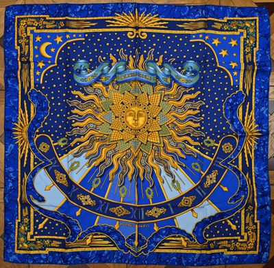 une tapisserie bleue et dorée sur laquelle est représenté un soleil