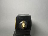 black and gold clock with a lion head on top of it
