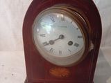 une petite horloge en bois avec des chiffres romains