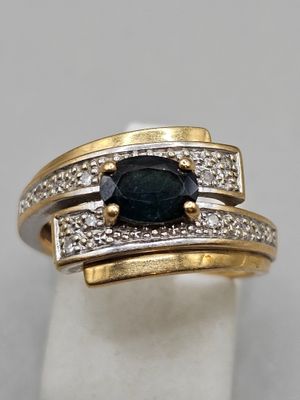 a close up of a ring with a sapphire and diamonds