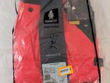 un gros plan sur une chemise rouge emballée dans du plastique, posée sur un lit