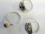 three silver rings with a pearl on a white surface