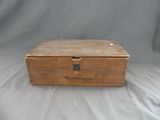 an old wooden box sitting on top of a white sheet