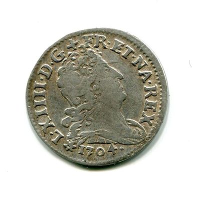 an old silver coin with a crown on it on a white surface