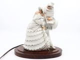une figurine représentant un couple de jeunes mariés posée sur une table