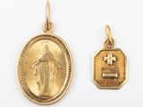 deux médailles d'or représentant une femme et une croix sur fond blanc