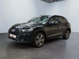 une Audi QX noire garée dans une grande pièce