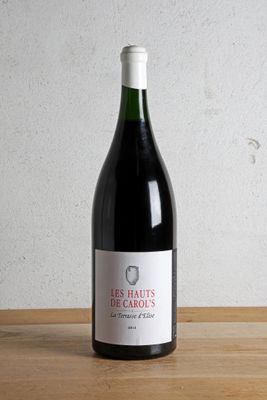 a bottle of red wine sitting on a wooden table
