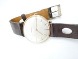 a watch that is sitting on top of a brown strap