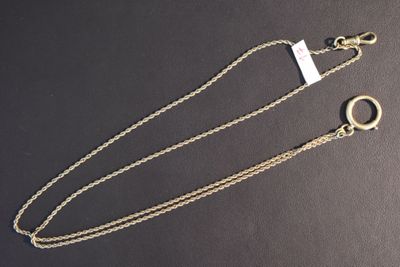 gros plan d'une chaîne en or sur laquelle est fixée une bague