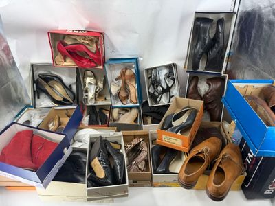 de nombreuses paires de chaussures dans des boîtes posées sur une table