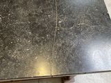 a black table with a marble top in the middle of a room