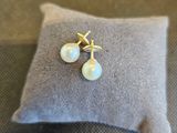 un gros plan sur une paire de boucles d'oreilles en perles posées sur un coussin