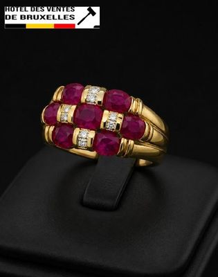 a close up of a gold ring with ruby and diamonds
