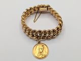 an image of a gold bracelet with a coin on it