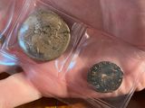 a person holding two coins in their hand on a table