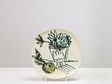 une assiette blanche ornée d'un motif floral noir et vert