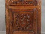 une vieille armoire en bois dont les portes et les tiroirs sont sculptés