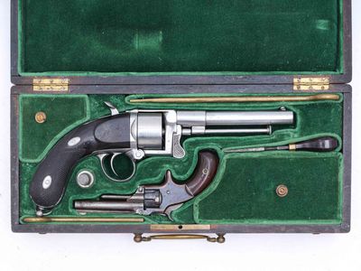un vieux pistolet dans un étui vert muni d'une poignée noire