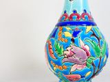 un vase bleu orné d'un oiseau, posé sur une table