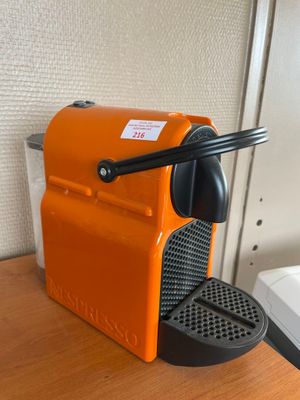 une machine à café orange posée sur une table à côté d'un évier