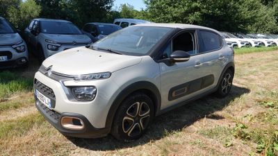 La voiture est garée dans l'herbe, à côté de nombreuses autres voitures.