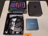 une boîte contenant des composants électroniques posée sur une table, à côté d'une boîte remplie de câbles