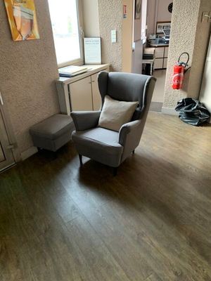 une chaise et une autre chaise dans une pièce au sol en parquet