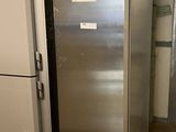a silver refrigerator in a room with a tiled floor