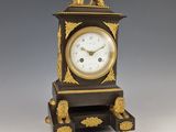 une horloge noire et dorée surmontée d'un lion