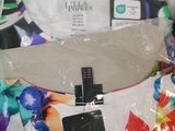 a white shirt with colorful flowers on it and a black tag on it
