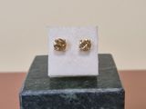 a close up of a pair of earrings sitting on top of a marble block