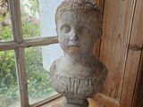 une statue représentant une femme assise sur une table en bois