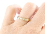 a person ' s hand with a gold ring on it
